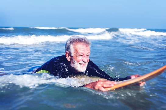 Man Surfing in the Ocean After Reversing Neuropathy Diagnosis